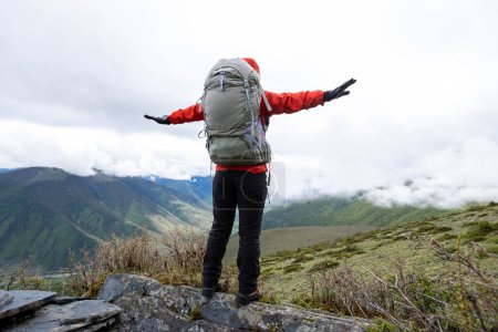 Téléchargez les photos : Femme de randonnée au sommet d'une montagne de haute altitude - en image libre de droit