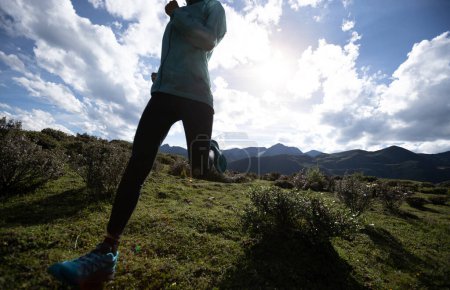 Foto de Mujer trail runner cross country running at high altitude mountain peak - Imagen libre de derechos