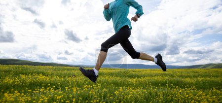 Foto de Mujer trail runner cross country corriendo en pastizales de gran altitud - Imagen libre de derechos