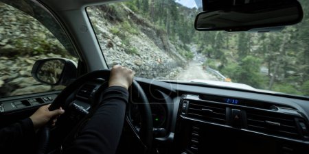 Téléchargez les photos : Mains conduisant voiture dans la forêt sentier de montagne, Chine - en image libre de droit