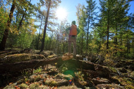 Téléchargez les photos : Femme de randonnée solo profiter du paysage du lever du soleil à la forêt d'automne - en image libre de droit