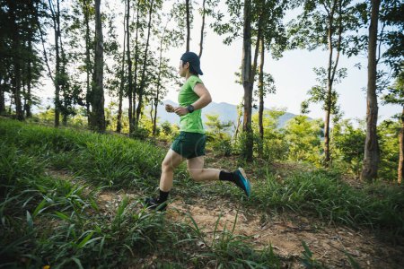 Foto de Corredor de senderos mujer corriendo en la montaña del bosque tropical - Imagen libre de derechos