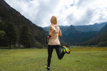 Foto de Mujer trail runner cross country running en montañas de gran altitud - Imagen libre de derechos