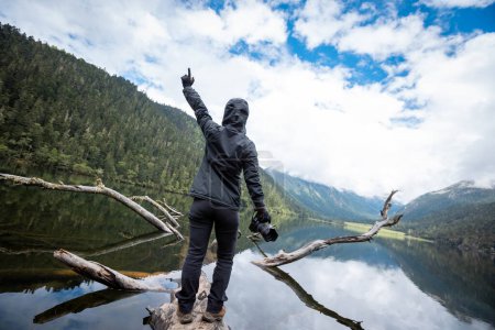 Téléchargez les photos : Femme photographe sur un pont à une planche dans les montagnes de haute altitude - en image libre de droit