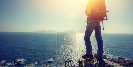 Photo for Hiker stand on sunrise seaside mountain cliff edge - Royalty Free Image