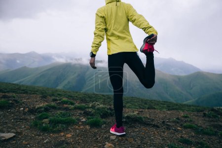 Foto de Mujer trail runner cross country running at high altitude mountain peak - Imagen libre de derechos