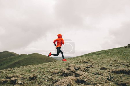 Photo for Woman trail runner cross country running to high altitude mountain peak - Royalty Free Image