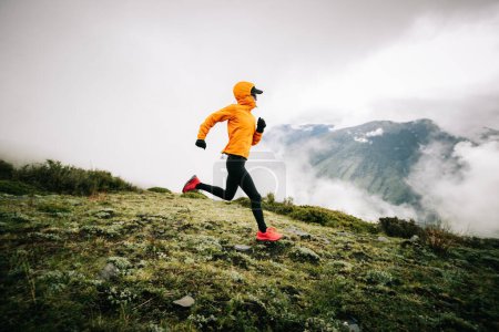 Femme trail runner cross country courir à haute altitude montagne pic