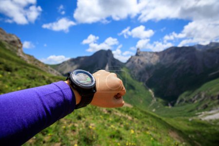 Photo for Hiker on high altitude mountain top checking the altimeter on the sports watch - Royalty Free Image