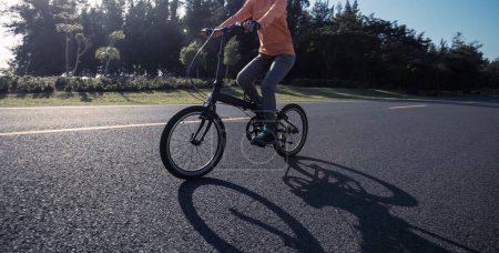 Foto de Montar bicicleta plegable en carretera soleada junto al mar - Imagen libre de derechos