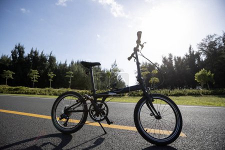 Photo for Folding bike on sunny seaside road - Royalty Free Image