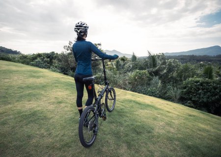 Foto de Montar bicicleta plegable a pico de montaña tropical - Imagen libre de derechos