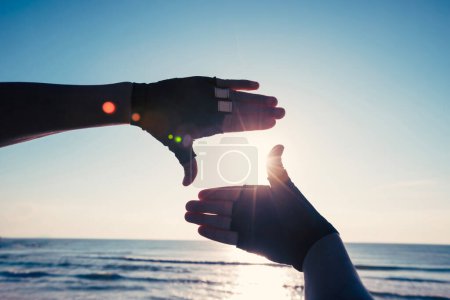 Téléchargez les photos : Mains en forme de cadre contre le lever du soleil - en image libre de droit
