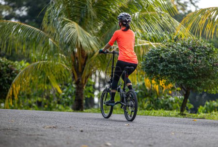 Photo for Riding folding bike on tropical road - Royalty Free Image