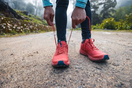Foto de Mujer trail runner atando cordones al aire libre - Imagen libre de derechos