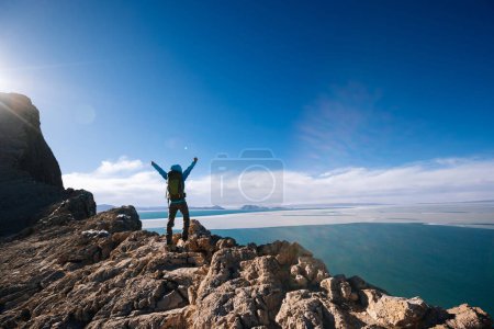 Photo for Woman hiker enjoy the view on mountain top cliff edge at lakeside - Royalty Free Image