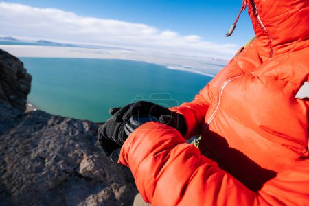 Téléchargez les photos : Femme randonneur vérifiant l'altitude sur smartwatch en hiver tibet - en image libre de droit