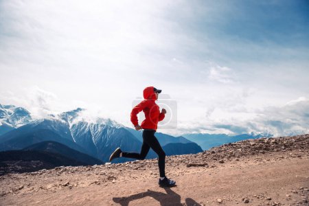 Woman trail runner cross country running at high altitude mountains