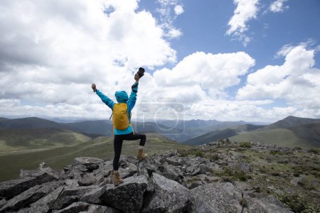Téléchargez les photos : Femme photographe prenant des photos sur le sommet de la montagne - en image libre de droit
