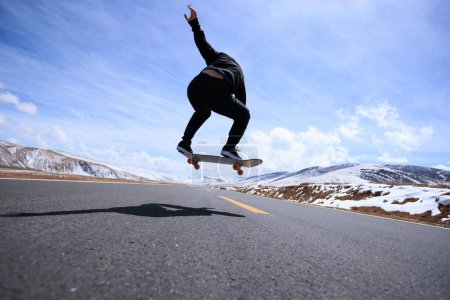 Foto de Skateboarder patinaje en carretera nevada país - Imagen libre de derechos