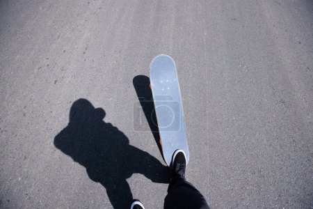Photo for Skateboarder skateboarding on road - Royalty Free Image