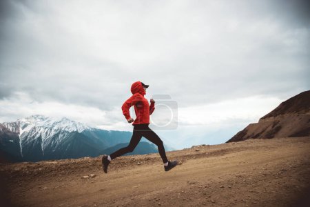 Foto de Mujer trail runner cross country running at high altitude mountains - Imagen libre de derechos