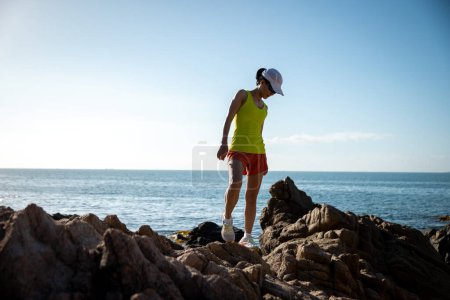 Téléchargez les photos : Femme coureuse courant au lever du soleil bord de mer montagnes rocheuses - en image libre de droit