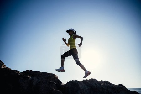 Téléchargez les photos : Femme coureuse courant au lever du soleil bord de mer montagnes rocheuses - en image libre de droit