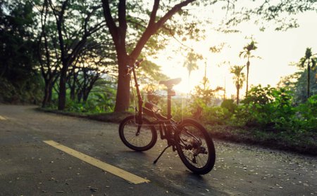 Photo for A folding bike on sunset road - Royalty Free Image