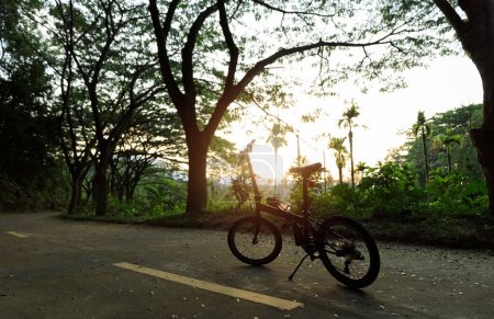 Foto de Una bicicleta plegable en el camino del atardecer - Imagen libre de derechos