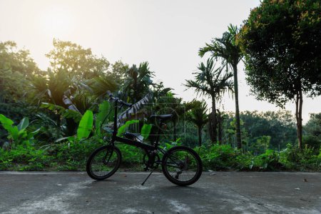 Foto de Una bicicleta plegable en el camino del atardecer - Imagen libre de derechos