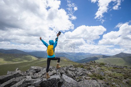 Téléchargez les photos : Femme photographe prenant des photos sur le sommet de la montagne - en image libre de droit
