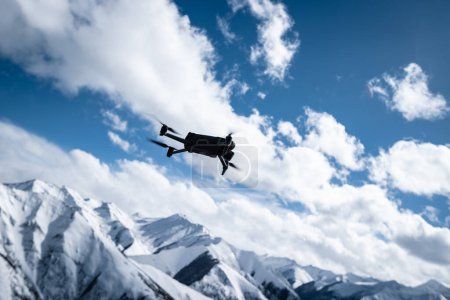Téléchargez les photos : Drone volant dans les montagnes de neige de haute altitude - en image libre de droit