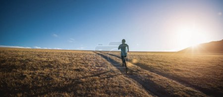 Photo for Woman trail runner cross country running in lakeside mountains - Royalty Free Image