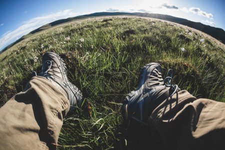 Téléchargez les photos : Randonneur relaxant sur les prairies fleuries d'été à haute altitude - en image libre de droit