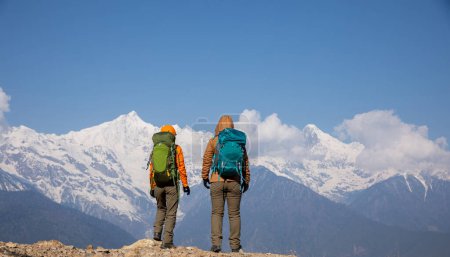 Photo for Two women backpackers hiking  in beautiful winter high altitude mountains - Royalty Free Image