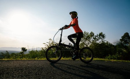 Photo for Riding folding bike on sunny mountain top road - Royalty Free Image