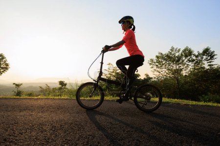 Foto de Montar bicicleta plegable en la carretera de montaña soleada - Imagen libre de derechos