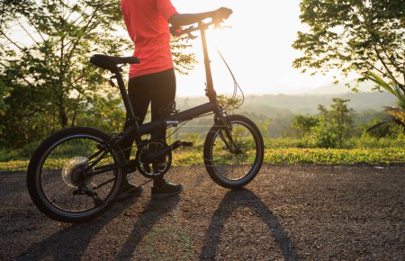 Photo for Riding folding bike on sunny mountain top road - Royalty Free Image
