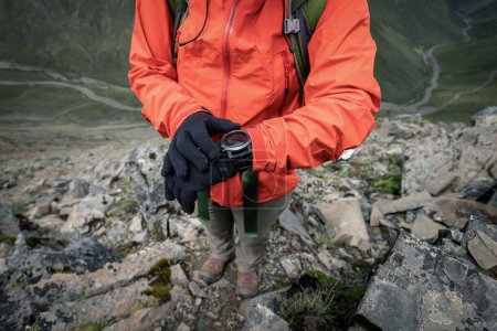 Photo for Successful woman hiker  set the sports watch at mountain top in tibet - Royalty Free Image