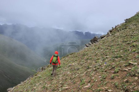 Photo for Woman hiker climbing to mountain top in tibet - Royalty Free Image