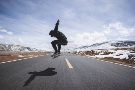 Foto de Skateboarder patinaje en carretera nevada país - Imagen libre de derechos