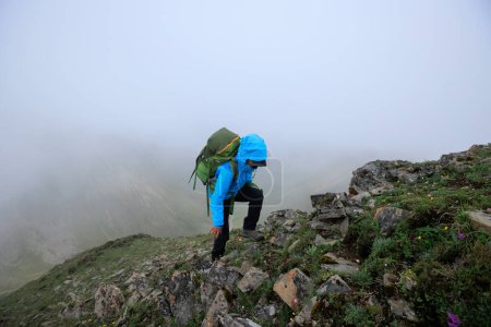 Téléchargez les photos : Femme randonneur escalade au sommet de la montagne au Tibet - en image libre de droit