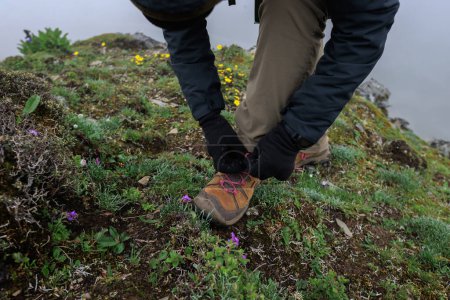 Téléchargez les photos : Femme randonneur attacher chaussures sur le sommet de la montagne - en image libre de droit