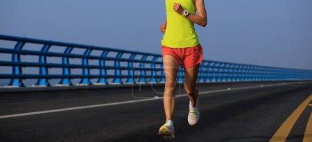 Photo for Fitness woman runner running on seaside bridge - Royalty Free Image