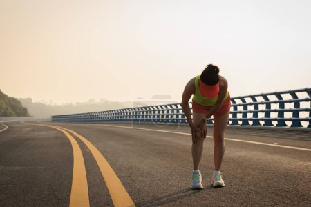 Foto de Correr deporte lesión corredor femenino tocando su rodilla - Imagen libre de derechos