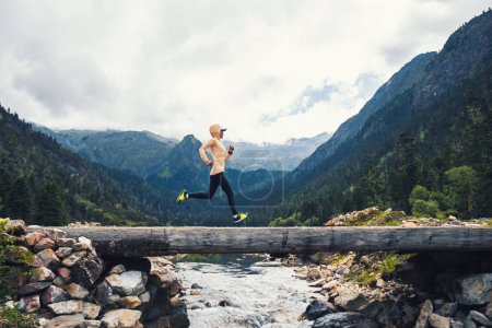 Foto de Mujer trail runner cross country running en montañas de gran altitud - Imagen libre de derechos