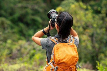 Téléchargez les photos : Femme photographe prenant des photos dans la montagne de printemps - en image libre de droit
