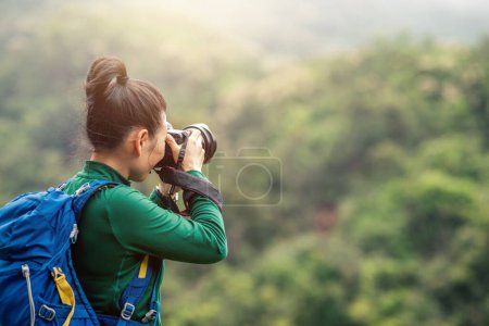 Foto de Mujer fotógrafa tomando fotos en la cima de la montaña primavera - Imagen libre de derechos