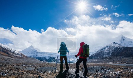 Photo for Two backpackers hiking in high altitude winter mountains - Royalty Free Image
